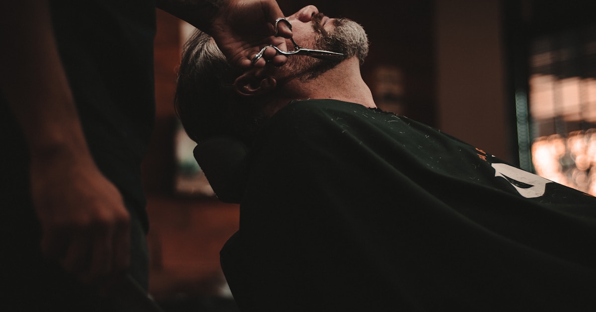 Barbero profesional realizando corte de cabello en barbería de CDMX
